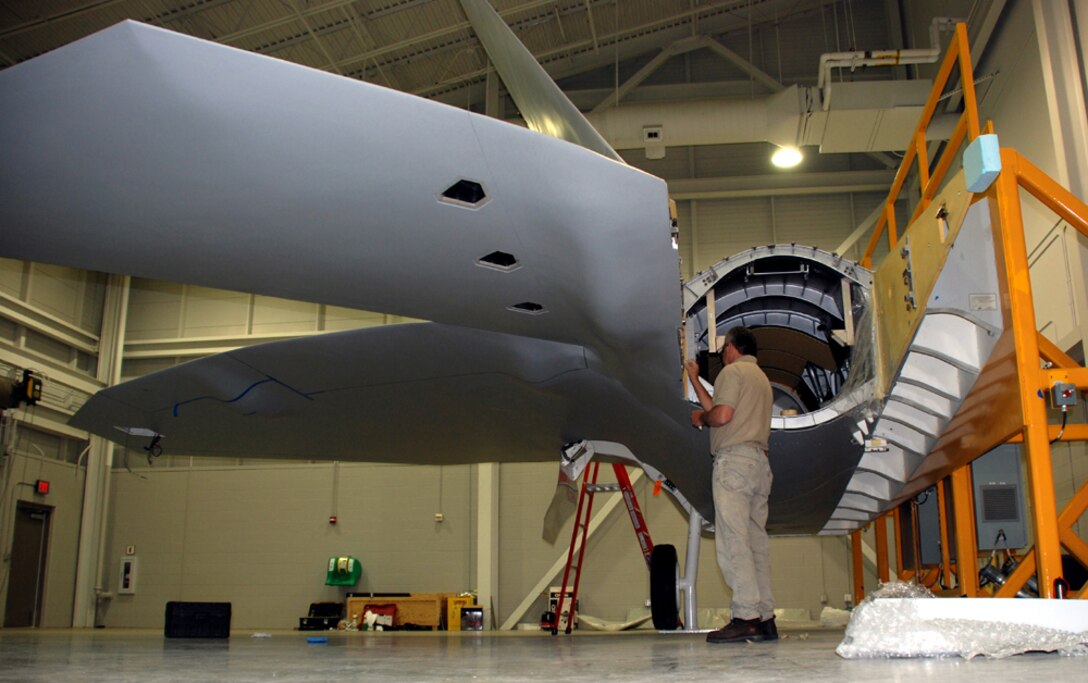 Buddy Cash, a master assembly mechanic with A.I.I. Services, works on the engine section of the first F-22A Raptor fuselage trainer at the new Raptor Maintenance Facility July 20. (U.S. Air Force photo/Airman 1st Class Jacob Corbin)