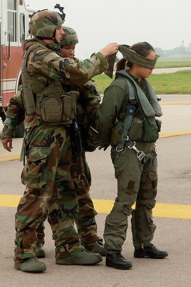 KUNSAN AIR BASE, Republic of Korea -- Airmen 1st Class Erik Halvorson and Caprell Edwards, 8th Security Forces Squadron, blindfold an unidentified individual off the base's flightline July 26. The scenario is part of the week-long Seventh Air Force Peninsula Combat Employment Readiness Exercise taking place July 23 - 27. Known as a 'PENCERE,' the exercise tests the ability of U.S. Air Force fighter wings to properly defend the Republic of Korea through the use of airpower. (U.S. Air Force photo/Senior Airman Giang Nguyen)