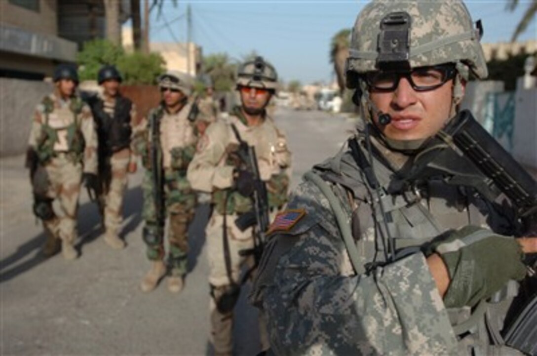 Staff Sgt. Galo Naranjo, U.S. Army, leads Iraqi army soldiers from the Strike Force Company of 3rd Battalion, 1st Brigade, 11th Iraqi Army Division during a search for explosive-making materials and unauthorized weapons in Qahirya, Iraq, on July 12, 2007.  Naranjo is attached to Alpha Troop, 3rd Squadron, 7th Cavalry Regiment, 2nd Brigade Combat Team, 3rd Infantry Division.  