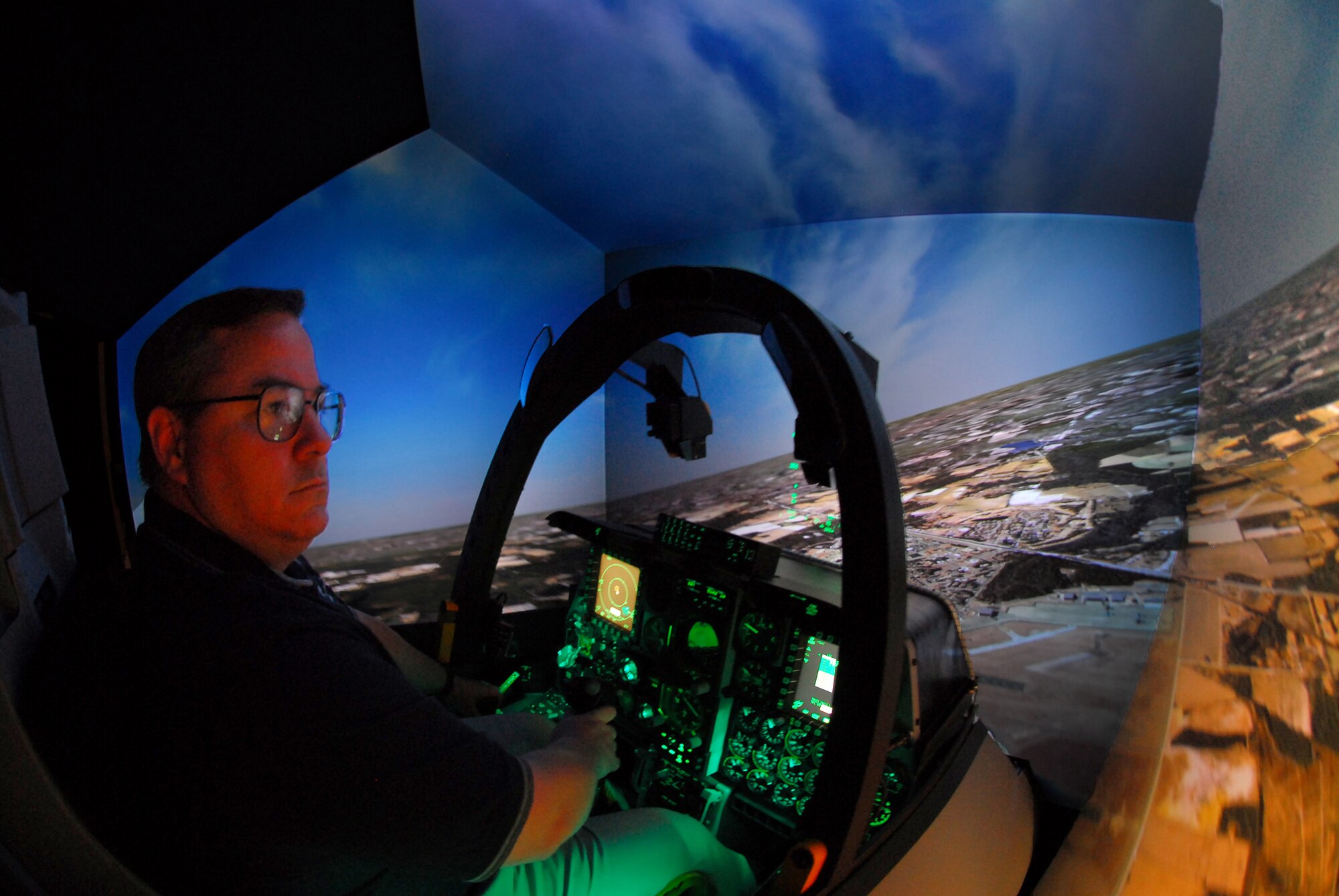 Steven Callich, A-10C Full Mission Trainer instructor, searches for a target while rolling into an attack run over a virtual Moody Air Force Base, Ga., July 27. The $3.2 million FMT is designed to exactly mimic the appearance and behavior of an upgraded A-10C. It can be linked with other simulators around the world to practice complex tactics.  (U.S. Air Force photo by Tech. Sgt. Parker Gyokeres)