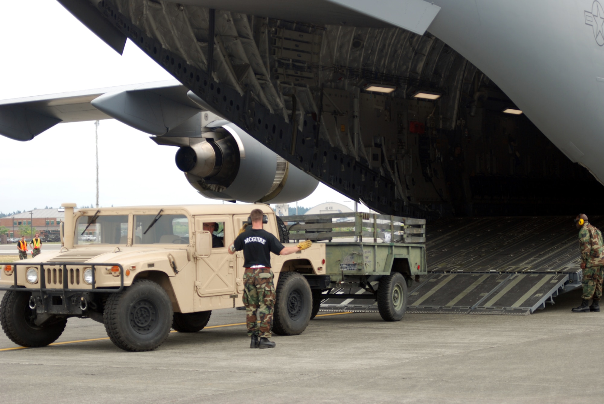 Members of the 305th Aerial Port Squadron, McGuire Air Force Base, N.J., perform an engine running on load during the Air Mobility Command Rodeo 2007 at McChord AFB, Wash., July 26. They completed their engine running on-and-off load event in 10 minutes, 36 seconds. They were required to complete the event in less than 12 minutes. (U.S. Air Force photo by Airman 1st Class Rebekah Phy)  