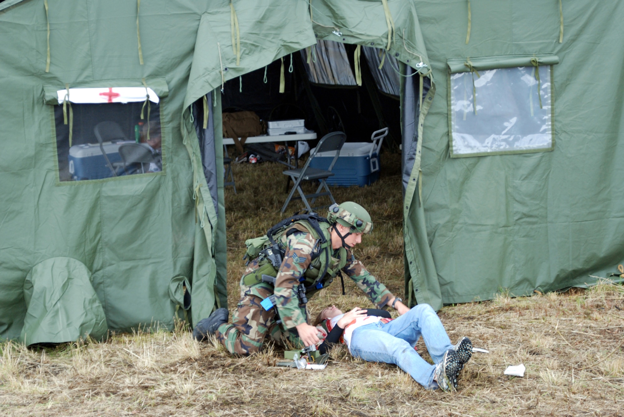 Senior Airman Peter Midura, 305th Security Forces Squadron Phoenix Raven, McGuire Air Force Base, N.J., helps a "wounded villager" during a scenario for the Rodeo 2007 Security Forces Tactics Event at McChord AFB, Wash., July 23. The event was designed to test their skills in different scenarios within the designated time. Photo by Airman 1st Class Rebekah Phy 