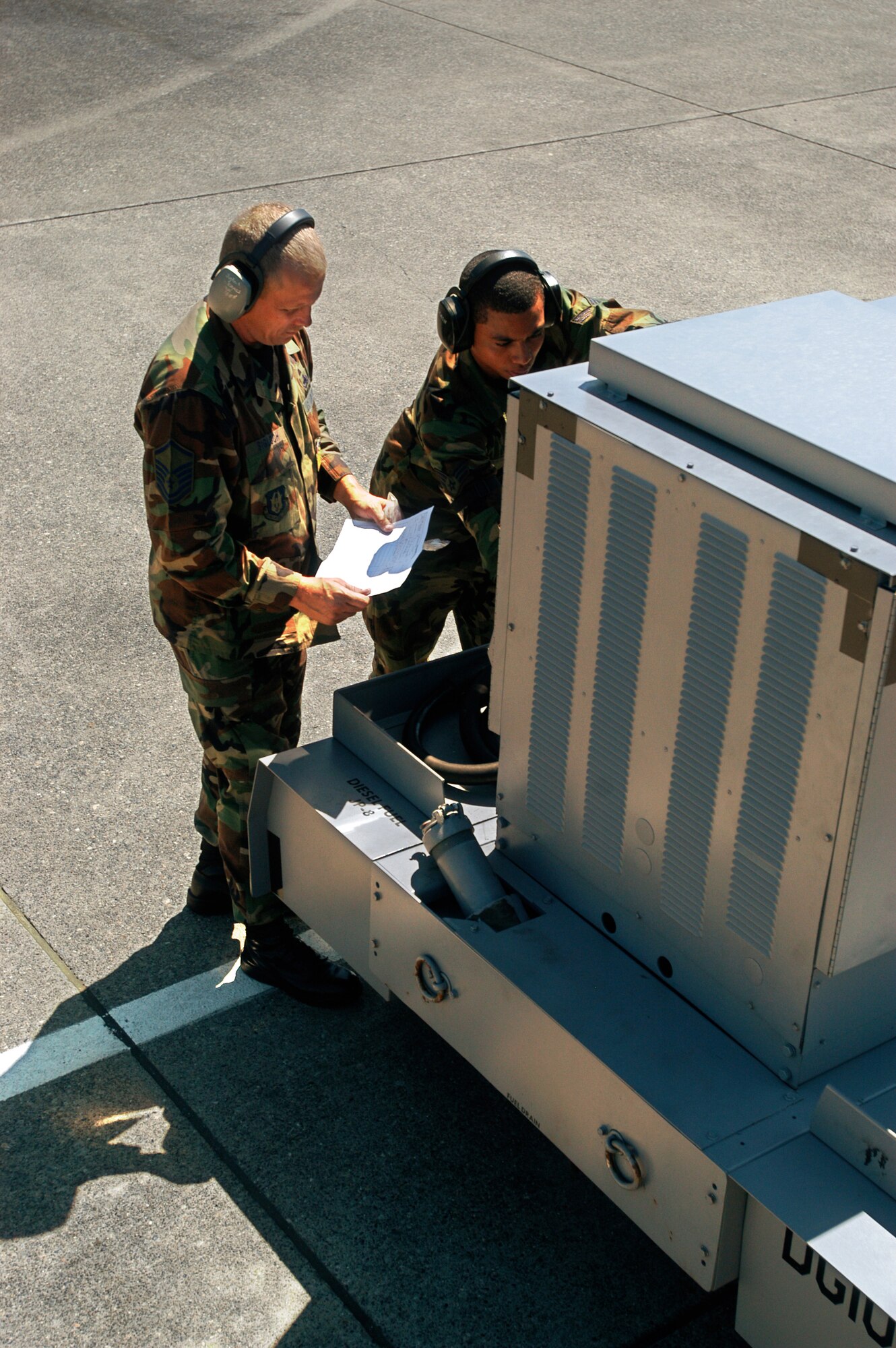 Master Sgt. PAul Sigloch, 514th Air Mobility Wing aircraft overhaul supervisor, and Senior Airman Arjuna Ramcharan, 305th Air Mobility Wing C-17 crewchief, inspect a A/N32-86 diesel generator set, which supplies elecrical power to their C-17 Globemaster III for Air Mobility Rodeo 2007 at McChord Air Force Base, Wash. The two are part of a blended team from McGuire AFB, N.J., made up of both Air Force active-duty and reserve personnel, at the Air Mobility Rodeo 2007. Both McGuire AFB and Charleston AFB, S.C., sent blended teams to Rodeo. Rodeo 2007 is a readiness competition of U.S. and international mobility air forces. It focuses on improving warfighting capabilities and support of the Global War on Terrorism. (U.S. Air Force photo/Staff Sgt. Mark R. W. Orders-Woempner)