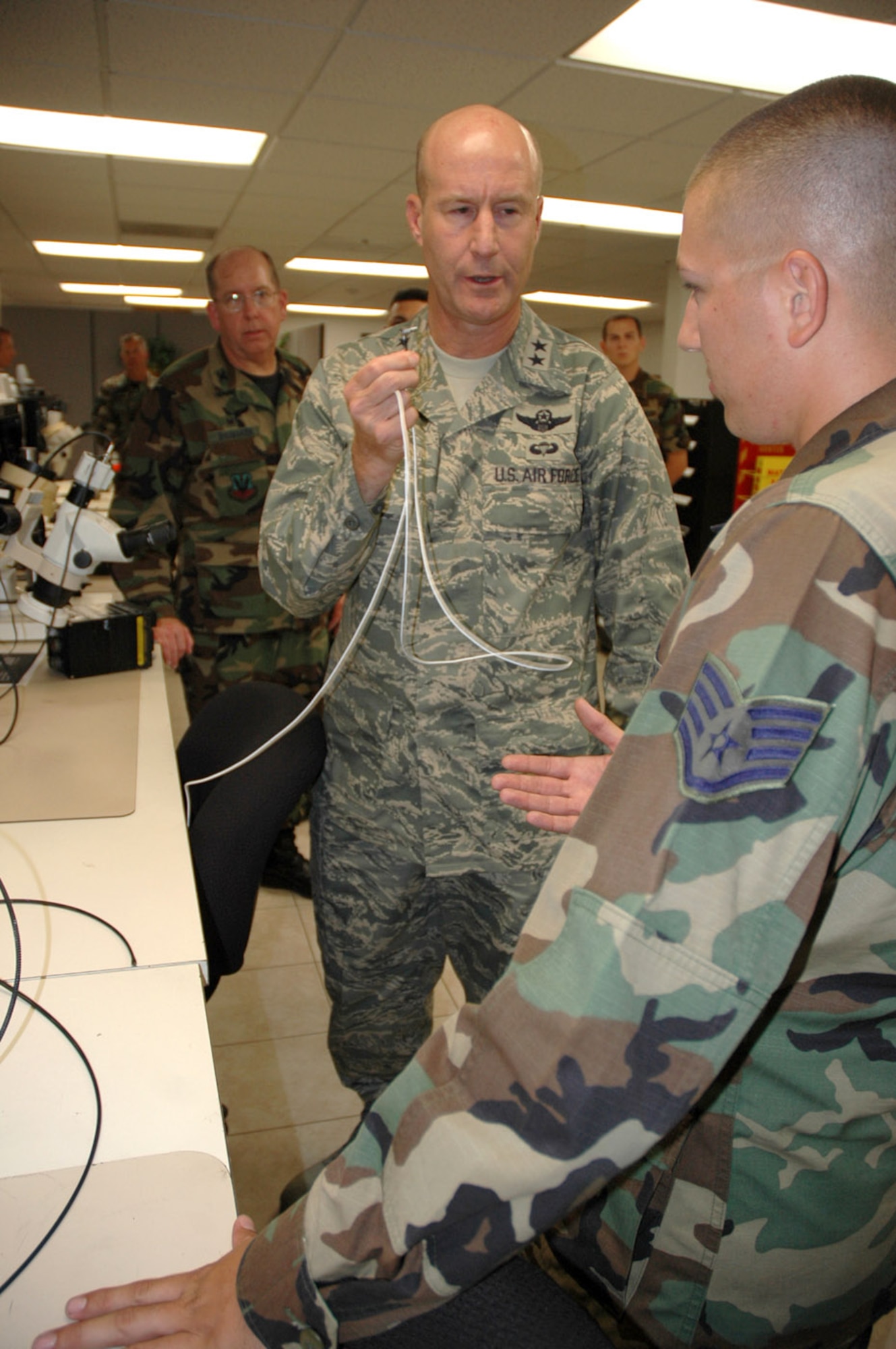 Staff Sgt. Robert Brutto briefs Maj. Gen. Douglas Raaberg on some of the techniques he and his fellow Air Force Repair Enhancement Program Airmen use to quickly repair critical aircraft parts on-site rather than send them to a depot for repair.  Sergeant Brutto is an AFREP technician in the 355th Maintenance Group at Davis-Monthan Air Force Base, Ariz.  General Raaberg, the director of air and space operations at Headquarters Air Combat Command, Langley Air Force Base, Va., was visiting the base and made time to stop by the AFREP shop.  (U.S. Air Force photo/Staff Sgt. Jake Richmond) 