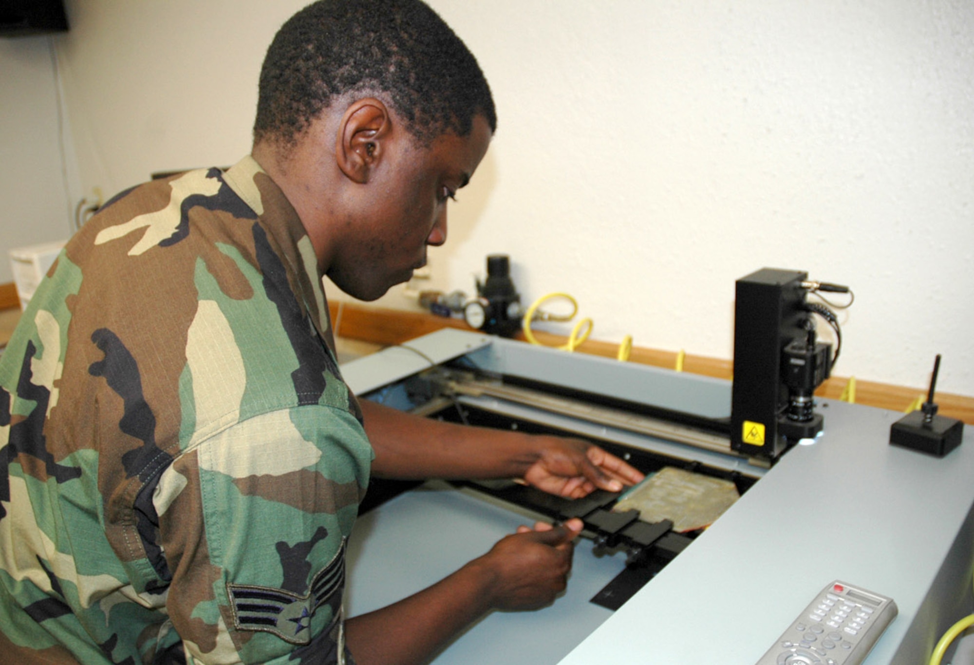 Senior Airman Torry Murray aligns a malfunctioning circuit card assembly in a troubleshooting card reader July 17.  Using a database that includes specifications for various circuit cards in use throughout the military, the machine runs diagnostic tests and reveals the cards' problems to the maintainer.  Airman Murray is an Air Force Repair Enhancement Program technician in the 355th Maintenance Group at Davis-Monthan Air Force Base, Ariz. (U.S. Air Force photo/Staff Sgt. Jake Richmond) 