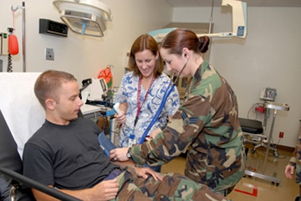 Jennifer Coleman, (middle) licensed vocational nurse, and Senior Airman Lori Bryant, aerospace medical technician, check the vital signs of Airman Michael Debonis, of the 12th Medical Group.