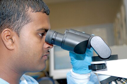 Staff Sgt. Ronnell Ramcharitar, 12th Medical Group laboratory technician, looks at a blood smear through a microscope. (Photo by Rich McFadden)