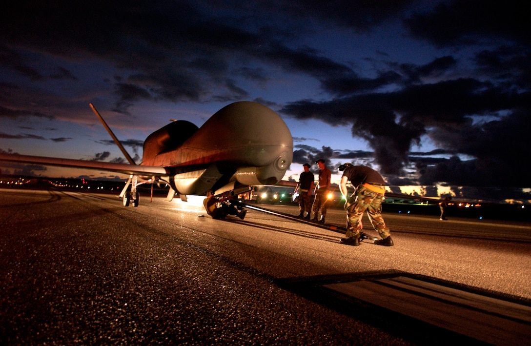 A flightline ground crew secures the Global Hawk unmanned aircraft system for towing to a secure hangar July 19 at Andersen Air Force Base, Guam. The UAS has a win span of 116 feet and is designed to cruise at extremely high altitudes. This marked the first time a Global Hawk deployed in support from the 9th Reconnaissance Wing at Beale Air Force Base, Calif. (U.S. Air Force photo/Senior Airman Miranda Moorer)                    