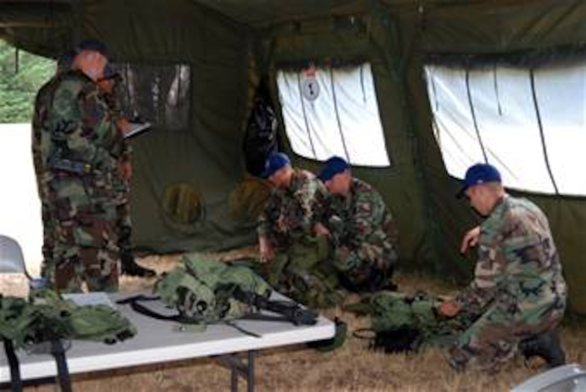 The security forces team of Tech. Sgt. Chris Wright and Senior Airmen Peter Midura and Andrew Prunitis, all from the 305th Security Forces Squadron at McGuire Air Force Base, N.J., get their gear on for the start of their security forces tactics competition run for Air Mobility Rodeo 2007 at McChord AFB, Wash., July 23. More than 65 people and three aircraft.  (U.S. Air Force Photo/Airman 1st Class Rebekah Phy)