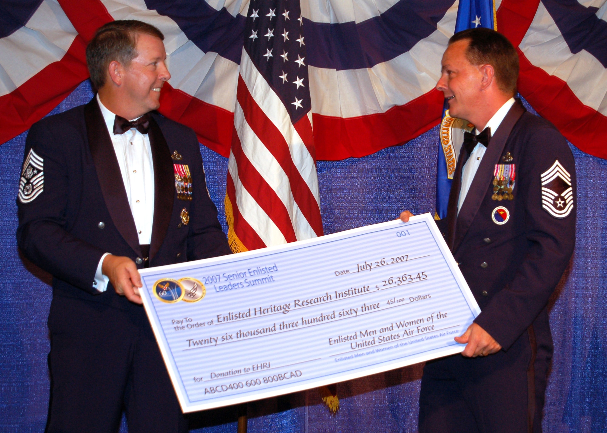 Chief Master Sgt. of the Air Force Rodney J. McKinley (left) presents a check for $26,363.45 to Chief Master Sgt. Malcolm McVicar during the Senior Enlisted Leaders Conference Heritage Dinner July 26 in Montgomery, Ala. Chief McVicar is the director of the Air Force Enlisted Heritage Hall. (U.S. Air Force photo/Master Sgt. Lee Roberts) 
