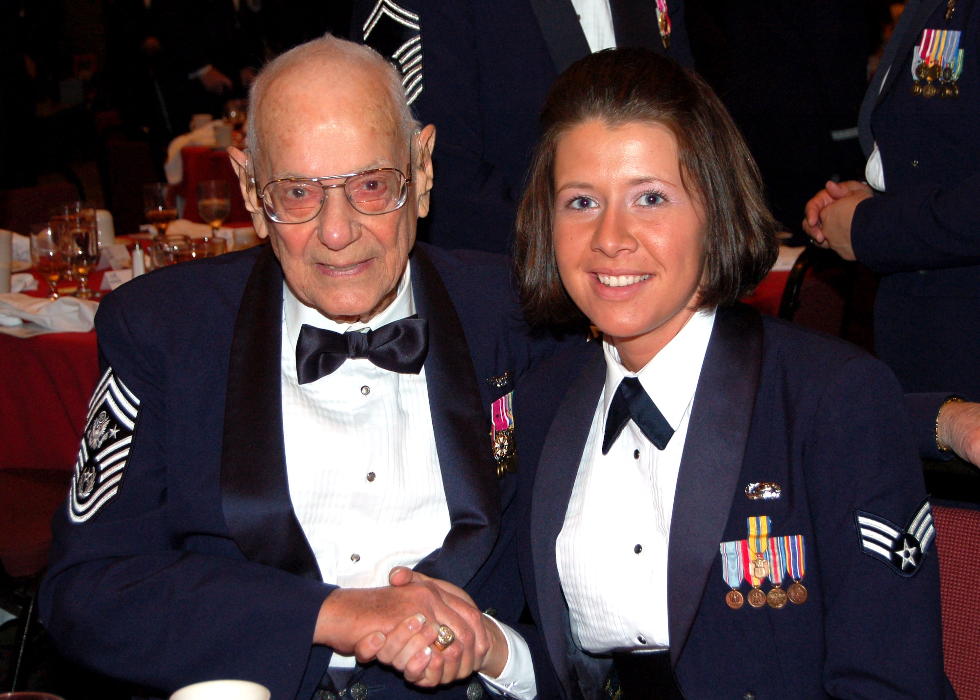 Senior Airman Natalie Napier gets her picture taken with Chief Master Sgt. of the Air Force Paul Wesley Airey during intermission of the Senior Enlisted Leaders Conference Heritage Dinner July 26 in Montgomery, Ala. The event was a celebration of the Air Force's 60th Anniversary and the 40th Anniversary of the inception of the office of the chief master sergeant of the Air Force. Airman Napier is assigned to Maxwell Air Force Base, Ala. (U.S. Air Force photo/Master Sgt. Lee Roberts) 
