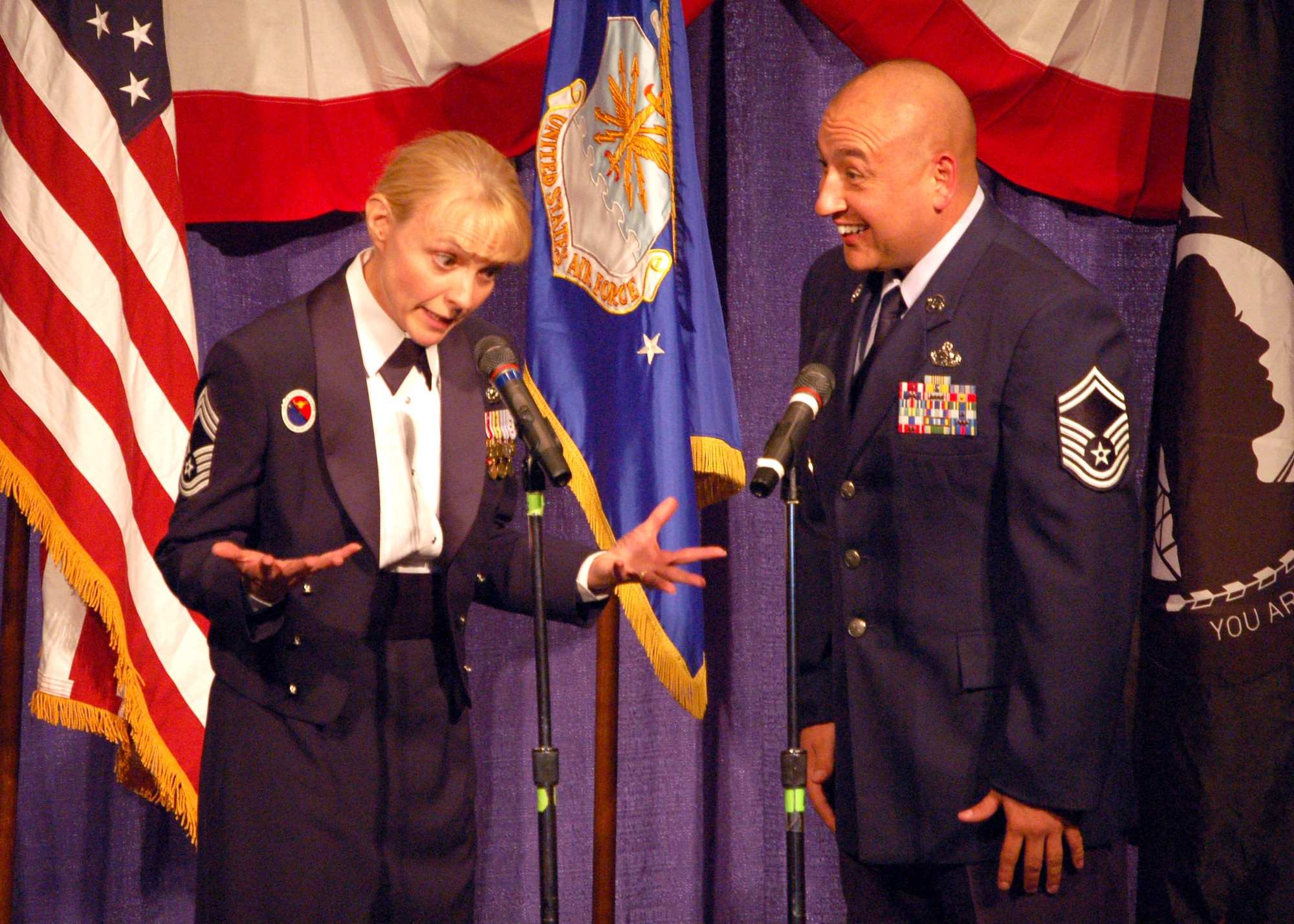 Chief Master Sgt. Pamela Derrow and Senior Master Sgt. Barraza act out a skit while introducing the period of service of the 12th Chief Master Sergeant of the Air Force Eric Benken's tenure during the Senior Enlisted Leaders Conference Heritage Dinner July 26 in Montgomery, Ala. Chief Derrow is the commandant of the Air Force Senior NCO Academy. (U.S. Air Force photo/Master Sgt. Lee Roberts) 
