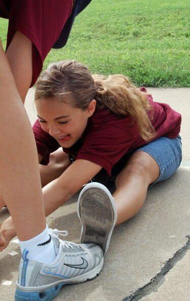 LAUGHLIN AIR FORCE BASE, Texas -- Carissa Lee, daughter of Lt. Col. Dean Lee, 87th Flying Training Squadron, and Seila Lee, stretches her arms out as far as she can, then Staff Sgt. Laurie Flores, 47th Aeromedical Dental Squadron, marks it to measure how flexible she is during the "President's Challenge" for the Drug Education For Youth summer program July 25.(U.S. Air Force photo by Airman Sara Csurilla) 
