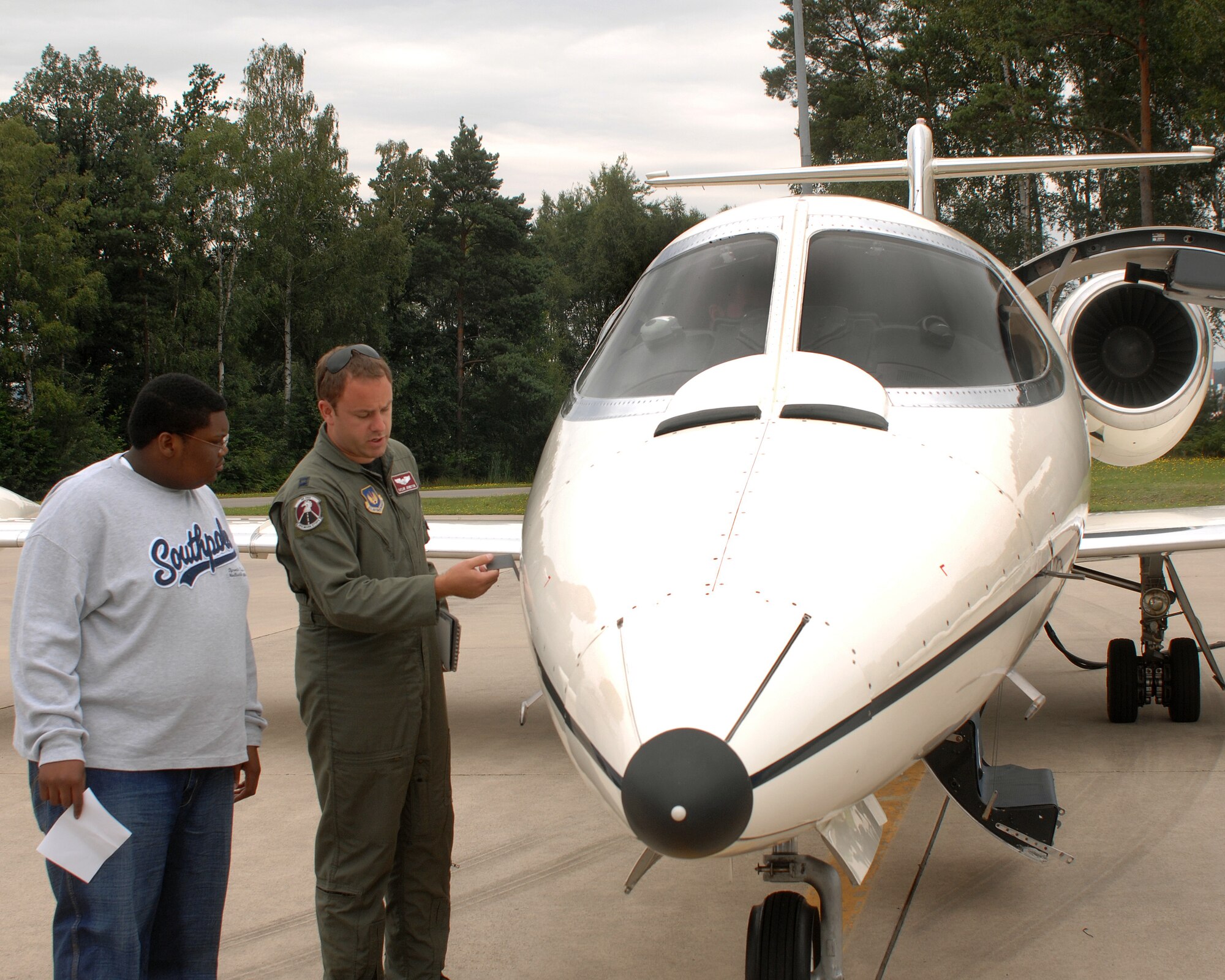 Capt. Taylor Johnston. 86th Operations Support Squadron,does a quick inspection of his aircraft with Jordan Perry July 21, 2007,  Jordan, who recenlty beat cancer, had the wish to visit Ramstein Air Base. Jordan's dad, Lester Perry, a retired first sergeant, was stationed in Germany in the early 90's. Ramstein Air Base personnel from different squadrons and the Dreams Come True foundation pulled together to make Jordan's dream a reality. (U.S. Air Force Photo/A1C Kenny Holston)