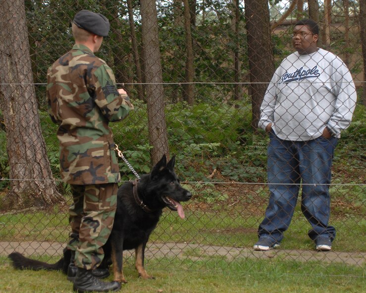 Staff Sgt. Jonathan Beaver, 435th Security Forces Squadron dog handler, explains to Jordan Perry how police dogs are used by security forces every day, before showing Jordan a demonstration July 21, 2007 at Ramstein Air Base Germany. Jordan, who recently beat cancer, had a wish to visit Ramstein Air Base. Jordan's dad, Lester Perry, a retired first sergeant, was stationed in Germany in the early 90's.   (U.S. Air Force photo/Airman 1st Class Kenny Holston)