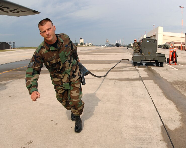 Tech. Sgt. Laurence Littleton, 86th Maintenance Operations Squadron, pulls an aerospace and ground equipment power cord toward a parked C-130 to give the plain external power while it's parked on the Ramstein flight line July 19, 2007 at Ramstein Air Base Germany. AGE equipment is used to give parked aircraft external power so the aircraft doesn't have to continue to run after its parked, which in turn saves the Air Force fuel and money and helps ensure mission success. (U.S. Air Force Photo/A1C Kenny Holston)