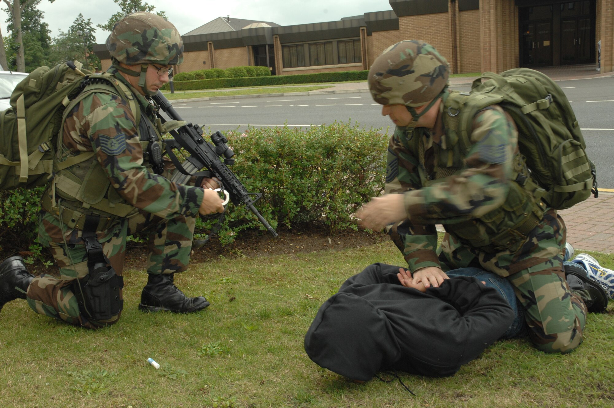 Master Sgt. Daniel Lambert and Tech. Sgt. Mike Steele, 48th Security Forces Squadron detain a mock-terrorist during an emergency management exercise on RAF Lakenheath July 26. EME’s are designed to test a base’s effectiveness when responding to major accidents. (U.S. Air Force photo by Airman 1st Class John Easterling)