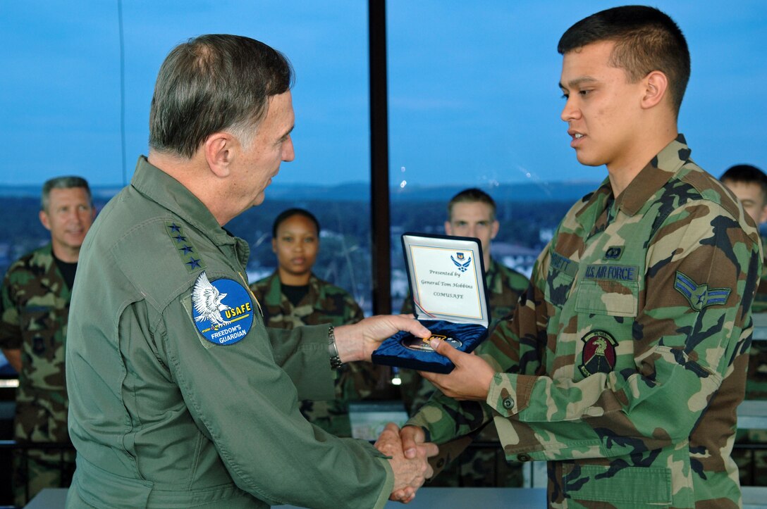 Gen. Tom Hobbins, U.S. Air Forces in Europe commander, presents 86th Operations Support Squadron Airman 1st Class Earl Pruett, air traffic controller with the ACE award at the Ramstein Air Traffic Control Tower July 20. The Airman aided safe landing of a Piper Cherokee and its four occupants during a dangerous thunderstorm in May


