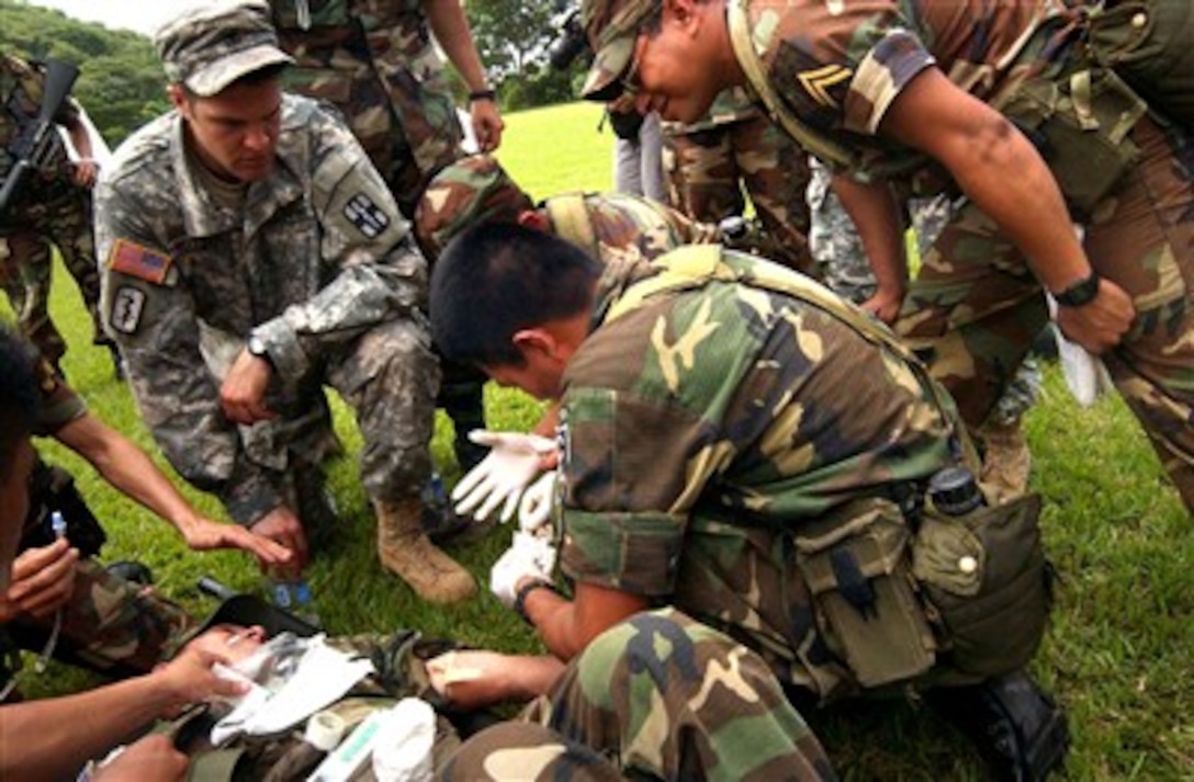 U.S. Army Spc. Jonathan Potter provides medical instruction during training with the Salvadoran military as a student prepares to administer an intravenous needle into a "wounded soldier", July 24, 2007. 