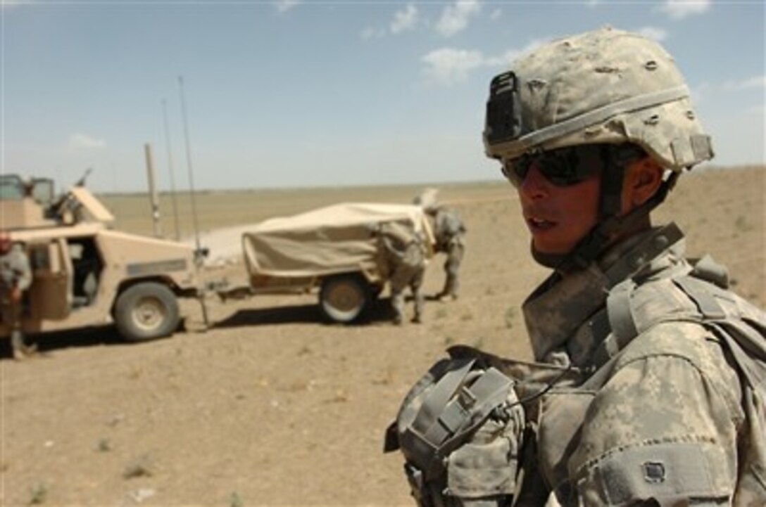 U.S. Army Pfc. Adam B. Head, a cavalry scout with Troop A, 4th Squadron, 73rd Cavalry Regiment, 4th Brigade Combat Team, 82nd Aiborne Division, Stands watch as supplies are loaded into the back of a nearby trailer, July 17, 2007. 