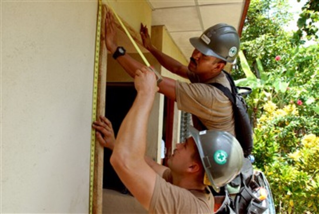 U.S. Navy Seabees measure as they build a doorframe at Jose Schendal Health Center in Corinto, Nicaragua, July 24, 2007.   The Seabees are attached to the hospital ship USNS Comfort which is on a four-month humanitarian deployment to Latin America and the Caribbean. 