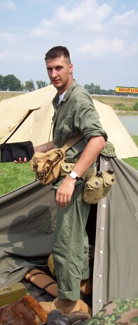 Seaman Andrew Garrison, a corpsman with Task Force 2nd Battalion, 2nd Marines, Regimental Combat Team 5, emerges from his tent during a World War II reenactment in Auburn, Ind., August 2007. He wears the uniform of a WWII corpsman in the photo, but he is currently serving in western al-Anbar province, Iraq.  Garrison has done over 30 reenactments and plans to do more when his deployment end