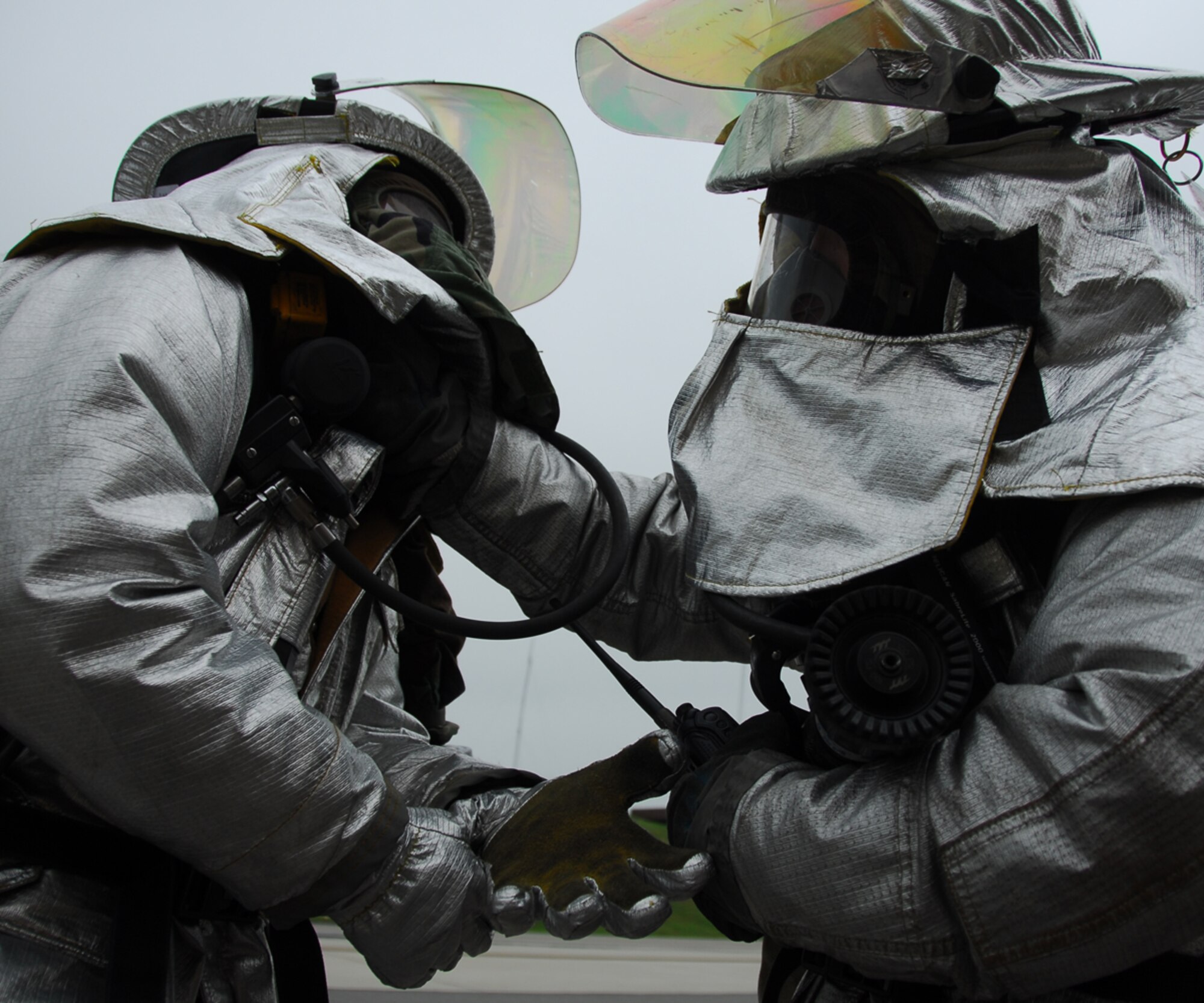 OSAN AIR BASE, Republic of Korea -- Two fireman of the 51st Civil Engineering Squadron do buddy checks during the Beverly Bulldog 07-03 exercise here on July 24, 2007. The exercise Beverly Bulldog 07-03 scenarios test Team Osan's ability to defend the base and conduct daily operations in a combat environment. (U.S. Air Force photo by Airman 1st Class Chad Strohmeyer)