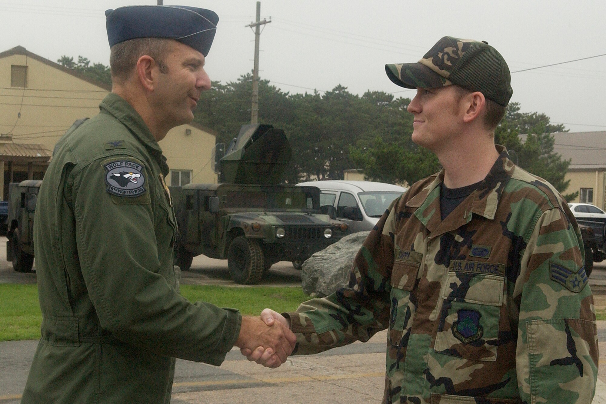 KUNSAN AIR BASE, Republic of Korea -- Col. Creig "Wolf 2" Rice, 8th Fighter Wing vice commander, congratulates Senior Airman Jake Capps of the 8th Maintenance Squadron, July 20. Airman Capps was the Wolf Pack's Pride of the Pack for the week of  July 23. (U.S. Air Force photo/Senior Airman Giang Nguyen)                              