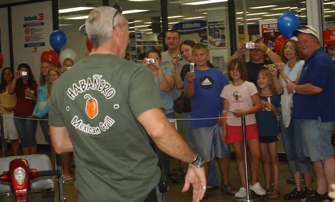 Team Malmstrom members who waited in line more than an hour for a guaranteed chance to get country singer Aaron Tippin's autograph, give him a hearty Air Force welcome on his entrance to the base exchange July 29. Mr. Tippin was in town to perform at the Montana State Fair and graciously accepted an invitation to meet his fans at Malmstrom. (U.S. Air Force photo/Valerie Mullett)   