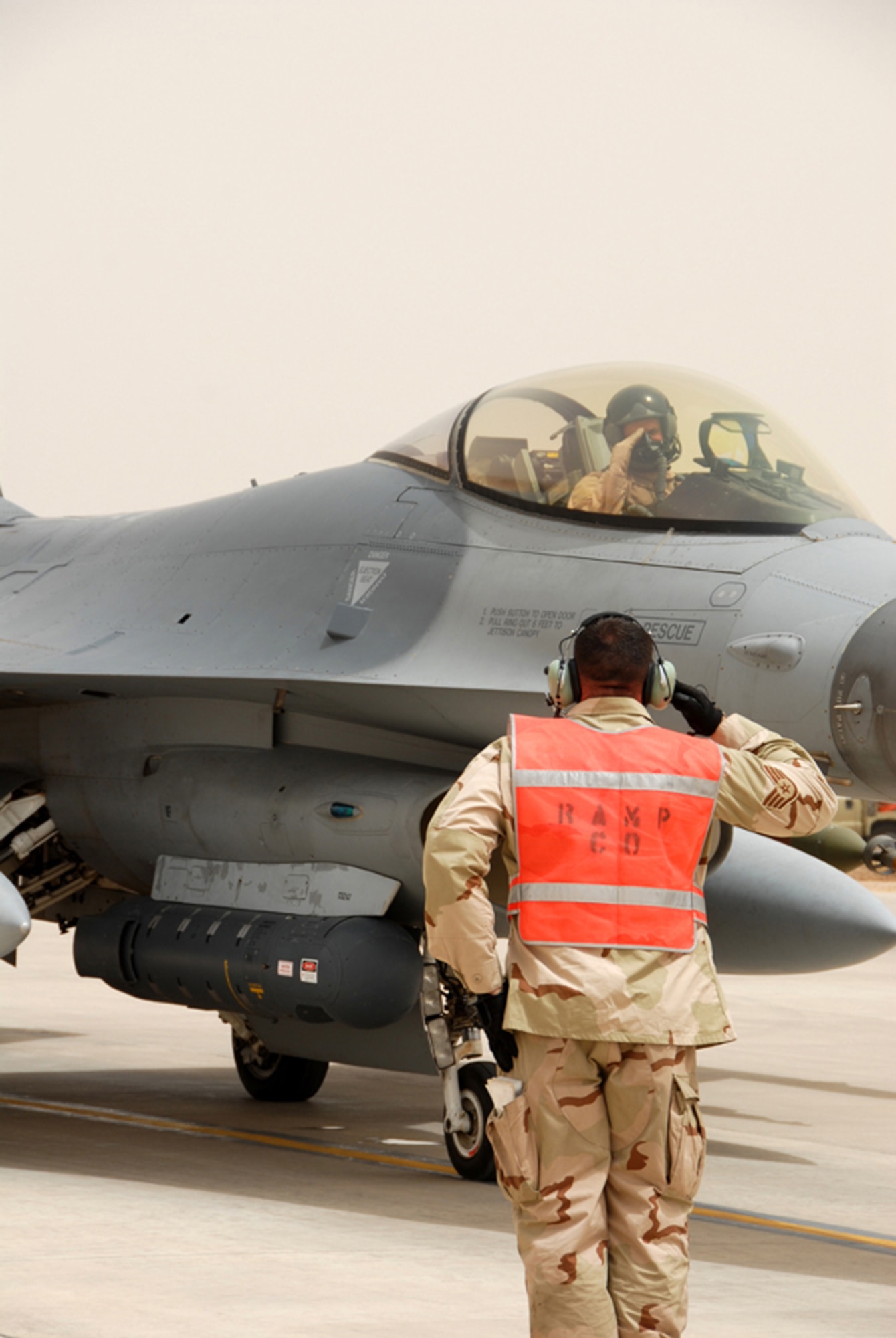An F-16 Fighting Falcon crew chief salutes the pilot before a close-air-support mission at Balad Air Base, Iraq.  F-16s flew CAS sorties exclusively for Operation Iraqi Freedom and provided multiple shows of force over Iraq July 28.  (U.S. Air Force photo)