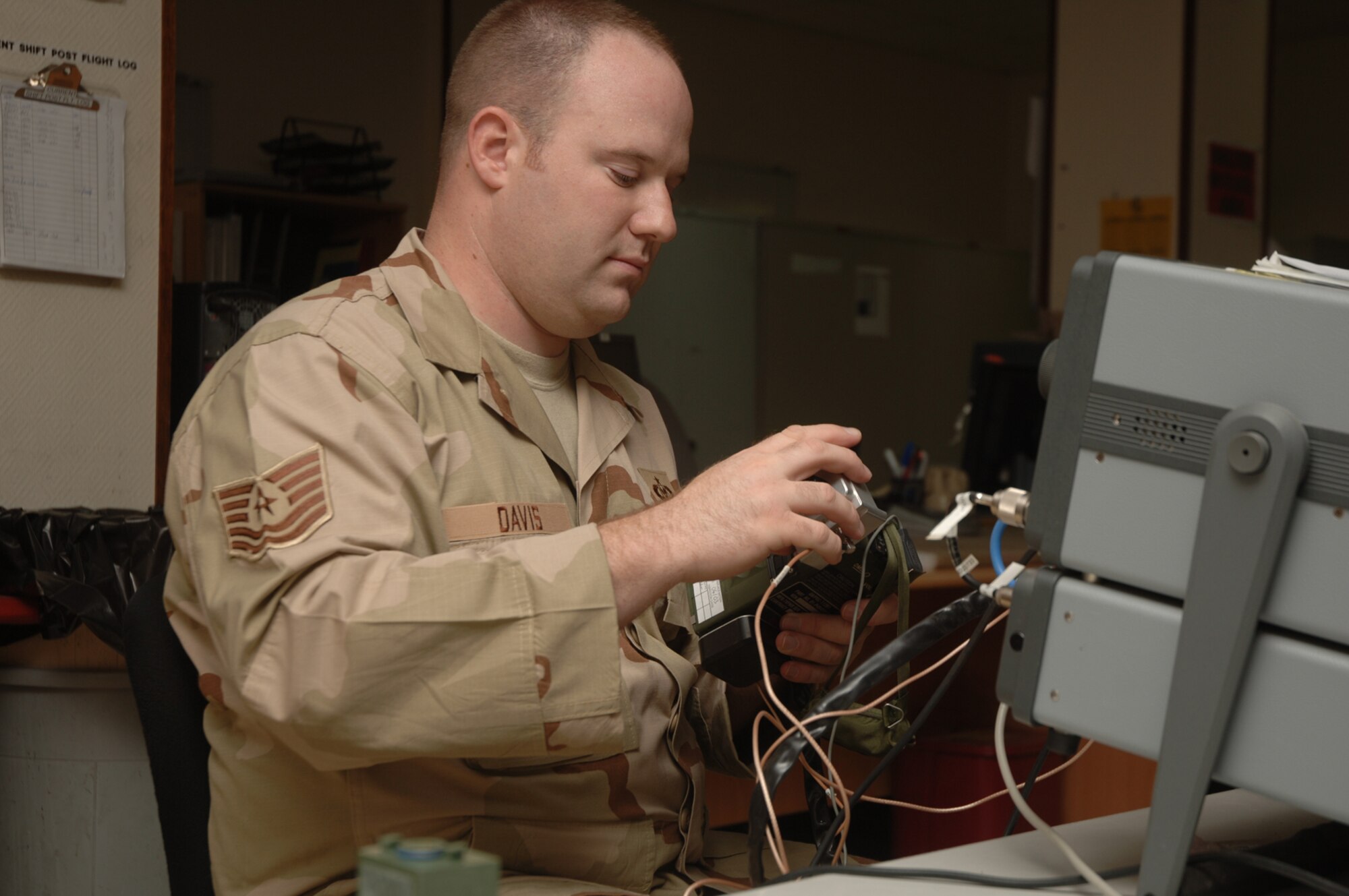 Tech. Sgt. Steven Davis, 379th Expeditionary Maintenance Squadron, tests a survival radio global positioning system. The 379th Expeditionary Operations Support Squadron’s Aircrew Life Support team and 379th EMXS’s Survival Equipment are merging into one. (U.S. Air Force photo by Master Sgt. Ken Stephens)