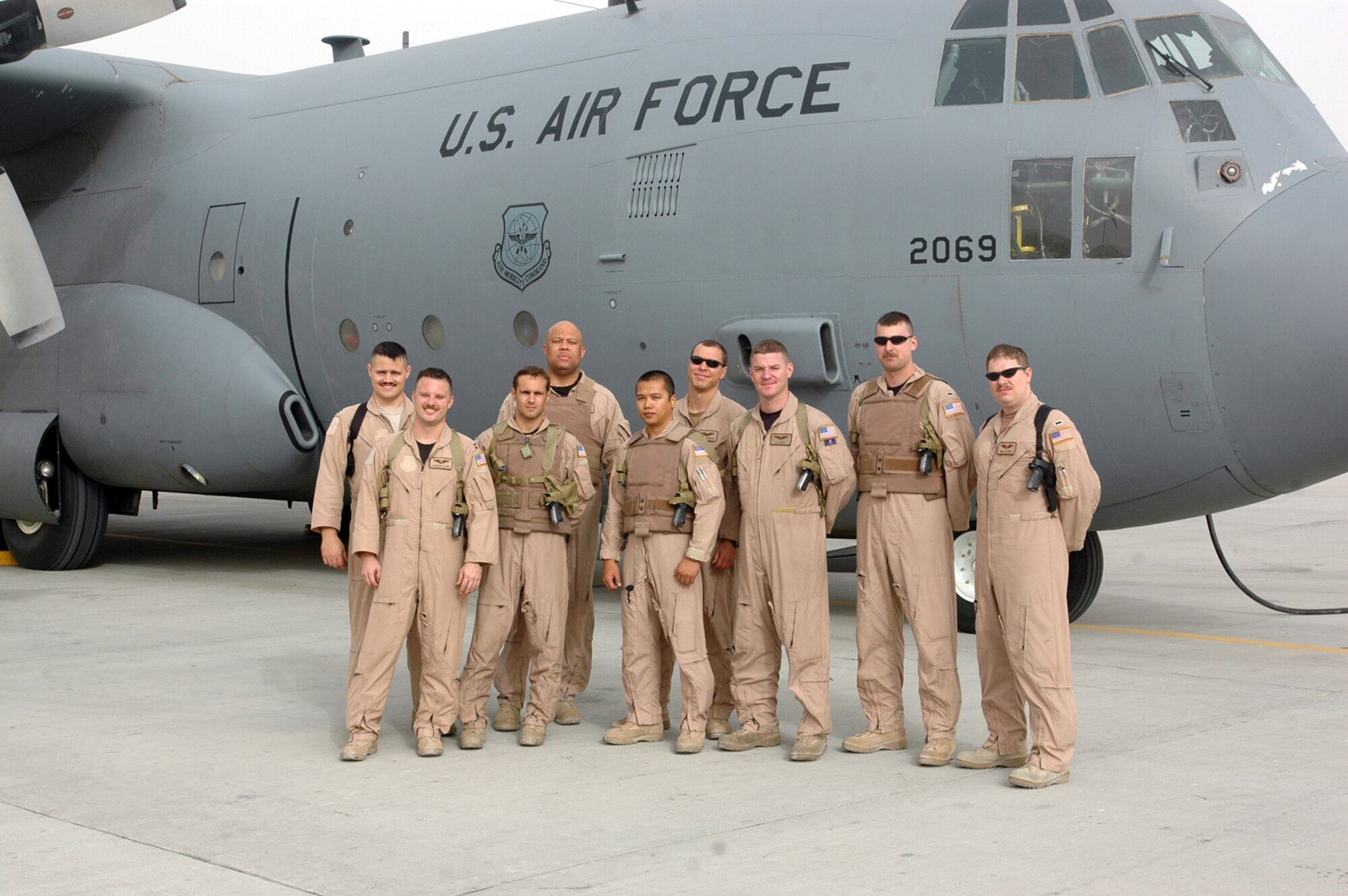 (From left) Capt. Jeremy Wagner, mission commander, Capt. Andrew Payne, instructor navigator, Tech. Sgt. Matt Rossi, instructor loadmaster, Master Sgt. Larry Lambert, senior loadmaster, Staff Sgt. Adonis Del Rosario, mission flight engineer Capt. Brett Cochran, pilot, Senior Airman Ronald Orr, mission loadmaster, 1st Lt. Mike Heddinger, co-pilot and 1st Lt. Mike Blohm, navigator, all with the 746th Expeditionary Airlift Squadron, successfully dropped 120,000 leaflets over a drop zone in the Helmand Province in Afghanistan July 22. The leaflets were designed to serve as a way to encourage civilians to stay out of harm’s way and not to harbor members of the Taliban. (U.S. Air Force photo by Capt. Teresa Sullivan)