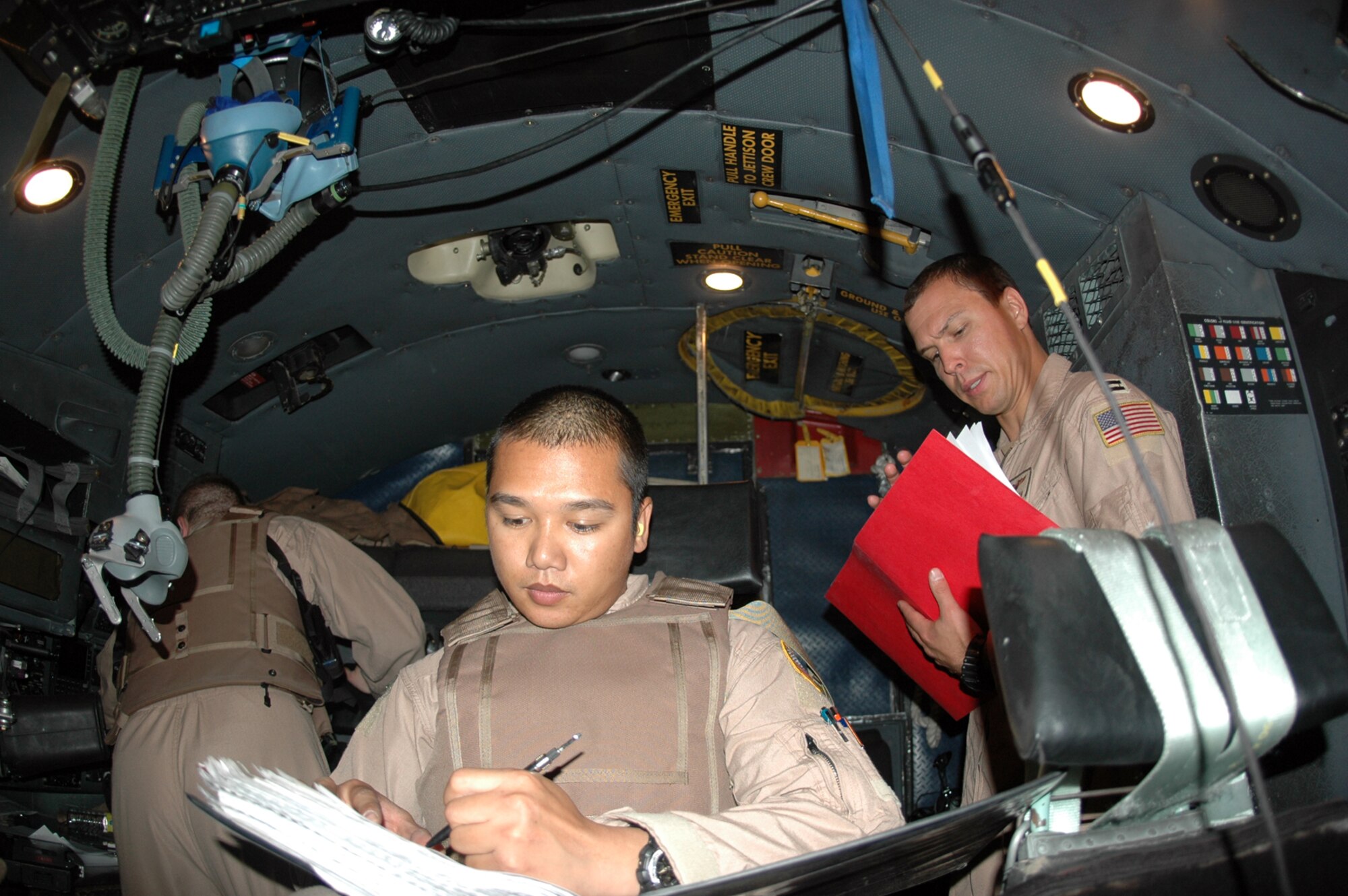 Staff Sgt. Adonis Del Rosario, 746th Expeditionary Airlift Squadron mission flight engineer (left) and Capt. Brett Cochran, 746th EAS C-130 pilot (right), review the play book one last time prior to departing Kandahar International Airport, Afghanistan, for an airdrop over the Helmand Province. (U.S. Air Force photo by Capt. Teresa Sullivan)