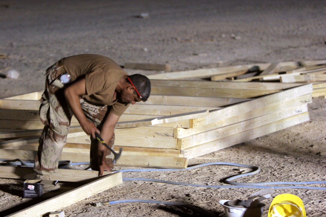 AL TAQADDUM, Iraq (July 30, 2007) ? An Iraqi army engineer nails together a frame for a Southwest Asia hut here July 30 for use at a combat outpost in Al Anbar province?s Thar Thar region.  The Marines of 8th Engineer Support Battalion, 2nd Marine Logistics Group (Forward) taught and helped the Iraqi engineers prefabricate the materials for structures to be occupied by Iraqi security forces.