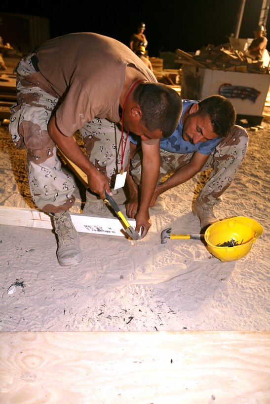 AL TAQADDUM, Iraq (July 30, 2007) ?  Iraqi army engineers prefabricate walls for structures here July 30.  The walls will be used for buildings at a combat outpost in Al Anbar province?s Thar Thar region.  The Marines of 8th Engineer Support Battalion, 2nd Marine Logistics Group (Forward) taught and helped the Iraqi engineers prefabricate the materials for structures to be occupied by Iraqi security forces.