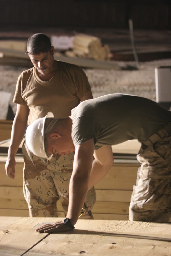AL TAQADDUM, Iraq (July 30, 2007) ? A Marine with 8th Engineer Support Battalion, 2nd Marine Logistics Group (Forward) shows an Iraqi army engineer how to put together a frame for a Southwest Asia hut here July 31.  The Marines of 8th ESB, 2nd MLG (Fwd) taught and helped the Iraqi engineers prefabricate the materials for structures to be occupied by Iraqi security forces.