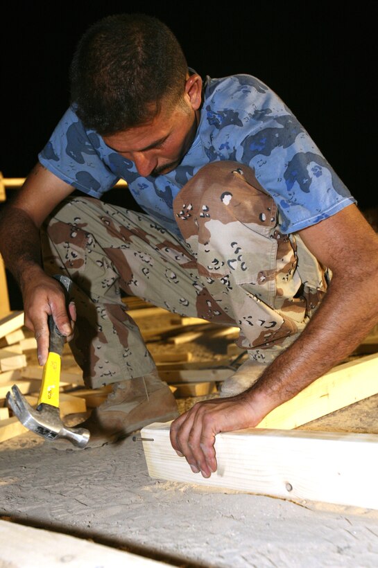 AL TAQADDUM, Iraq (July 30, 2007) ? An Iraqi army engineer nails together a frame for a Southwest Asia hut here July 31 for use at a combat outpost in Al Anbar province?s Thar Thar region.  The Marines of 8th Engineer Support Battalion, 2nd Marine Logistics Group (Forward) taught and helped the Iraqi engineers prefabricate the materials for structures to be occupied by Iraqi security forces.