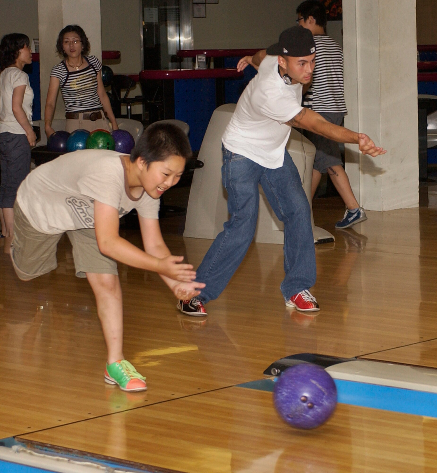 KUNSAN AIR BASE, Republic of Korea -- Airman 1st Class Joseph Putis, 8th Security Forces Squadron and In Song Pak bowling together at the bowling center on July 30 here. The 8th SFS hosted a bowling event with 17 children from a Gunsan City orphanage. (U.S. Air Force photo/SrA Giang Nguyen)

                               