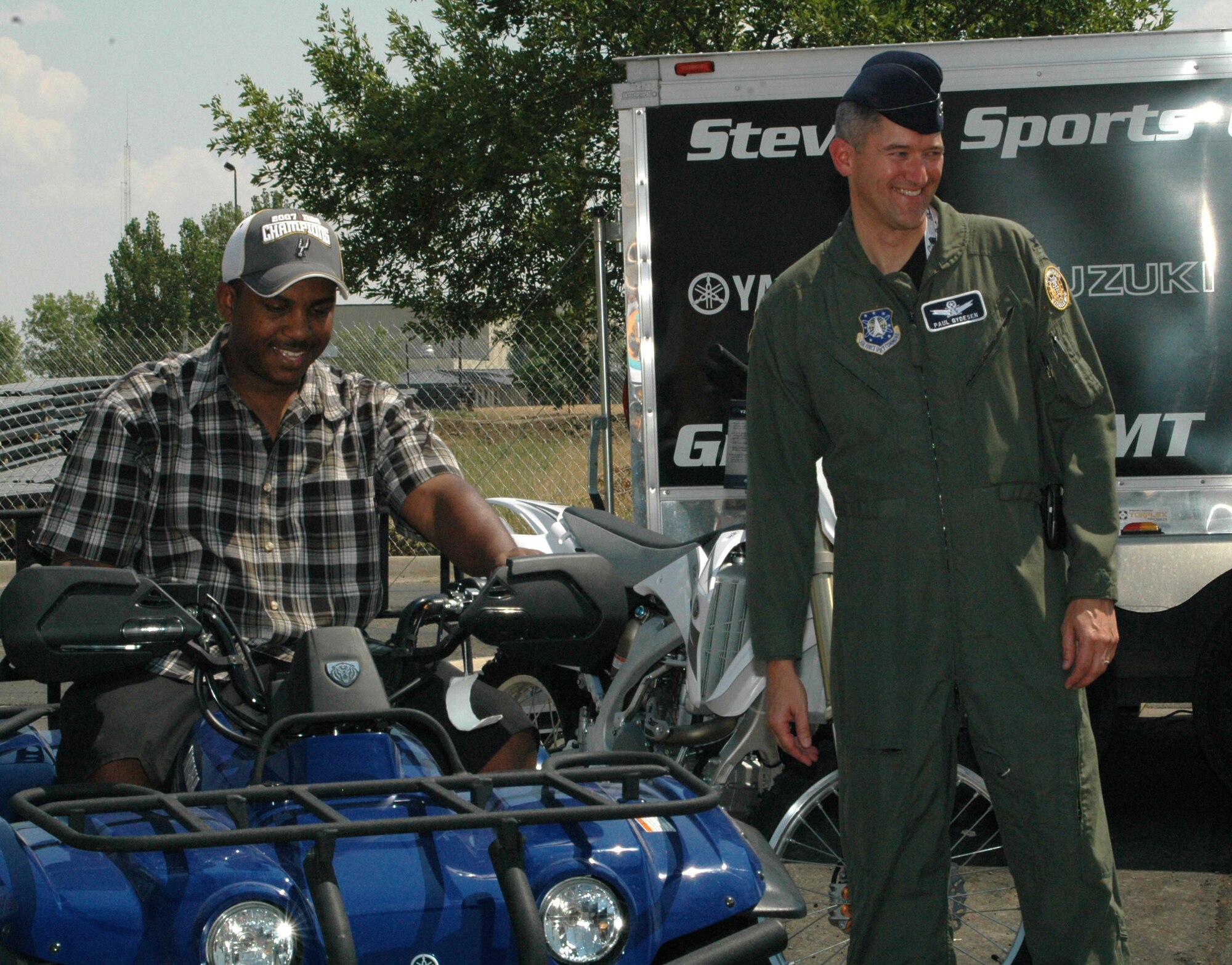 Tech. Sgt. Robert Pierce, 341st Medical Operations Squadron dental technician, sits on his new four-wheeler he won at the Malmstrom Air Force Base picnic after his name was pulled from 735 contest entries. Col. Paul Gydeson, 341st Space Wing vice commander, presented the prize to him at the free, annual summer event sponsored by the 341st Services Squadron and several area businesses. (U.S. Air Force photo/Airman 1st Class Dillon White).