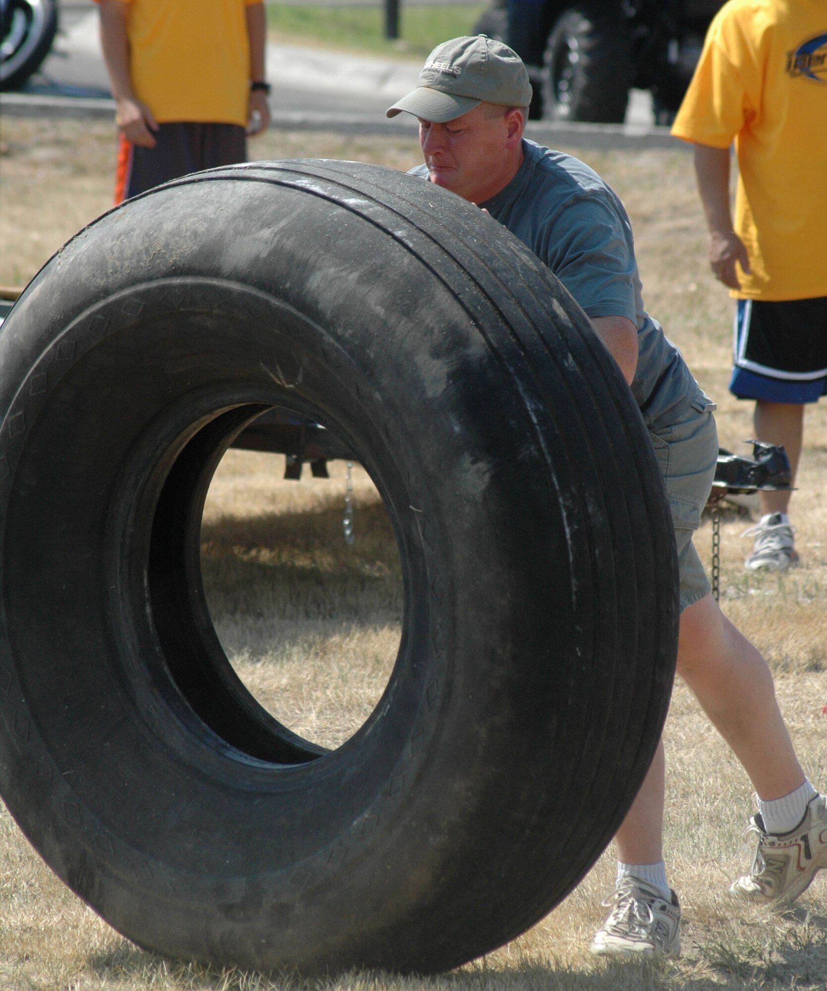Master Sgt. Nathan Brett, 341st Security Forces Squadron weapons system superintendent, flips a tire in the Grizzly Challenge Competition during the "Cruisin' the Summer" base picnic July 27. More than 2,500 people attended the free, annual barbeque at Malmstrom Air Force Base, Mont. (U.S. Air Force photo/Airman 1st Class Dillon White).
