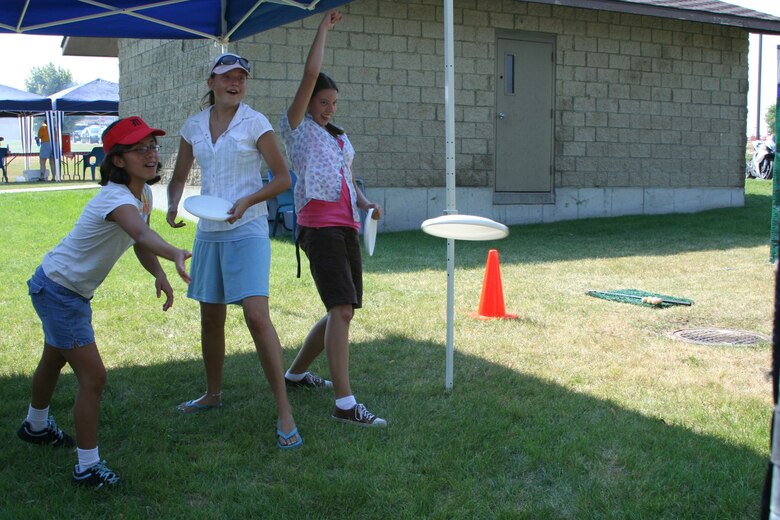 Little Warriors Valerie and Ashley, both 13, and Jessica, 15, throw frisbees at the frisbee toss during the "Cruisin' the Summer" base picnic July 27 at Malmstrom Air Force Base, Mont. (U.S. Air Force photo/Senior Airman Eydie Sakura).