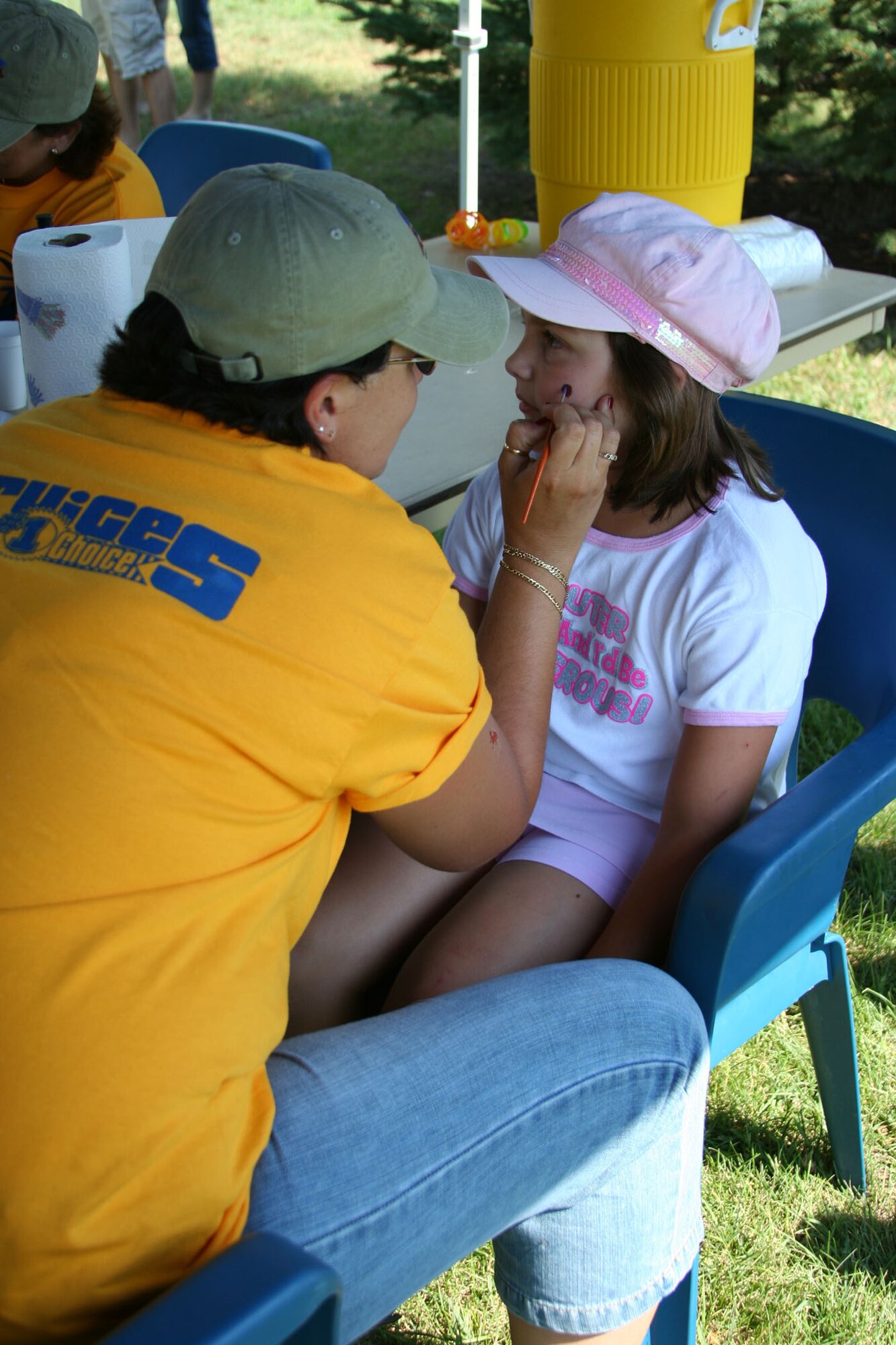Little Warrior Caitlin, 8, gets her face painted by Lyndsee Frost, 341st Services Squadron, at the "Cruisin' the Summer" base picnic July 27. Face painting was just one of many children's events offered at the picnic. More than 2,500 people attended the free, annual barbeque at Malmstrom Air Force Base, Mont. , sponsored by the 341st Services Squadron and local businesses.(U.S. Air Force photo/Senior Airman Eydie Sakura).