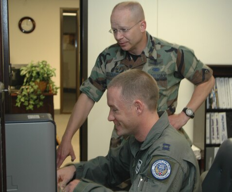 Col. David Durgan, 341st Operations Group commander, looks on as Capt. Russell Herring explains his work. (U.S. Air Force photo / Airman 1st Class Emerald Ralston)