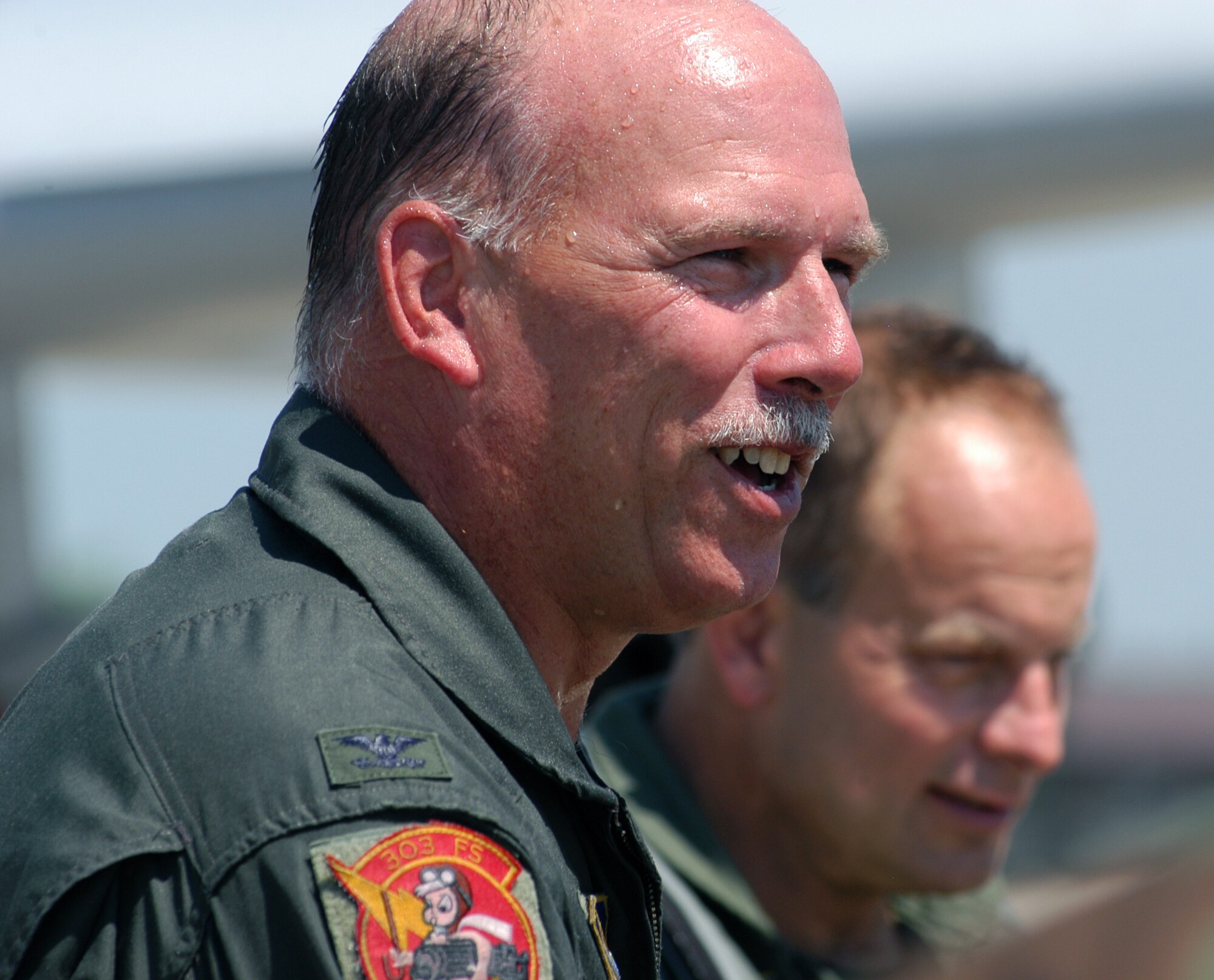 Col. Mark Ronco, looking wet after being sprayed with a fire hose following his final flight as an A-10 pilot in the 442nd Fighter Wing, receives congratulations from other wing members July 15, 2007.  Colonel Ronco served as an instructor pilot, flight commander, assistant operations officer, squadron commander, group commander and vice wing commander in the wing during his 16-year Air Force Reserve career in the wing. He is slated to become the military liaison to the Kansas emergency management office.  (U.S. Air Force photo/Maj. David Kurle)