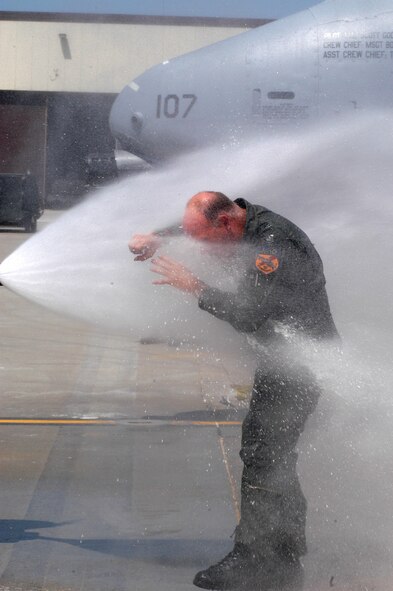 Col. Mark Ronco gets hit with a stream of water from a firehose held by his daughter after landing from his final A-10 flight in the 442nd Fighter Wing.  Colonel Ronco served as an A-10 instructor pilot, flight commander, assistant operations officer, squadron commander, group commander and vice wing commander during his Air Force Reserve career in the wing.  The hose down is an Air Force tradition for a pilot's "fini-flight."  Colonel Ronco will become the military liaison to the State of Kansas' emergency management office.  (U.S. Air Force photo/Maj. David Kurle)  