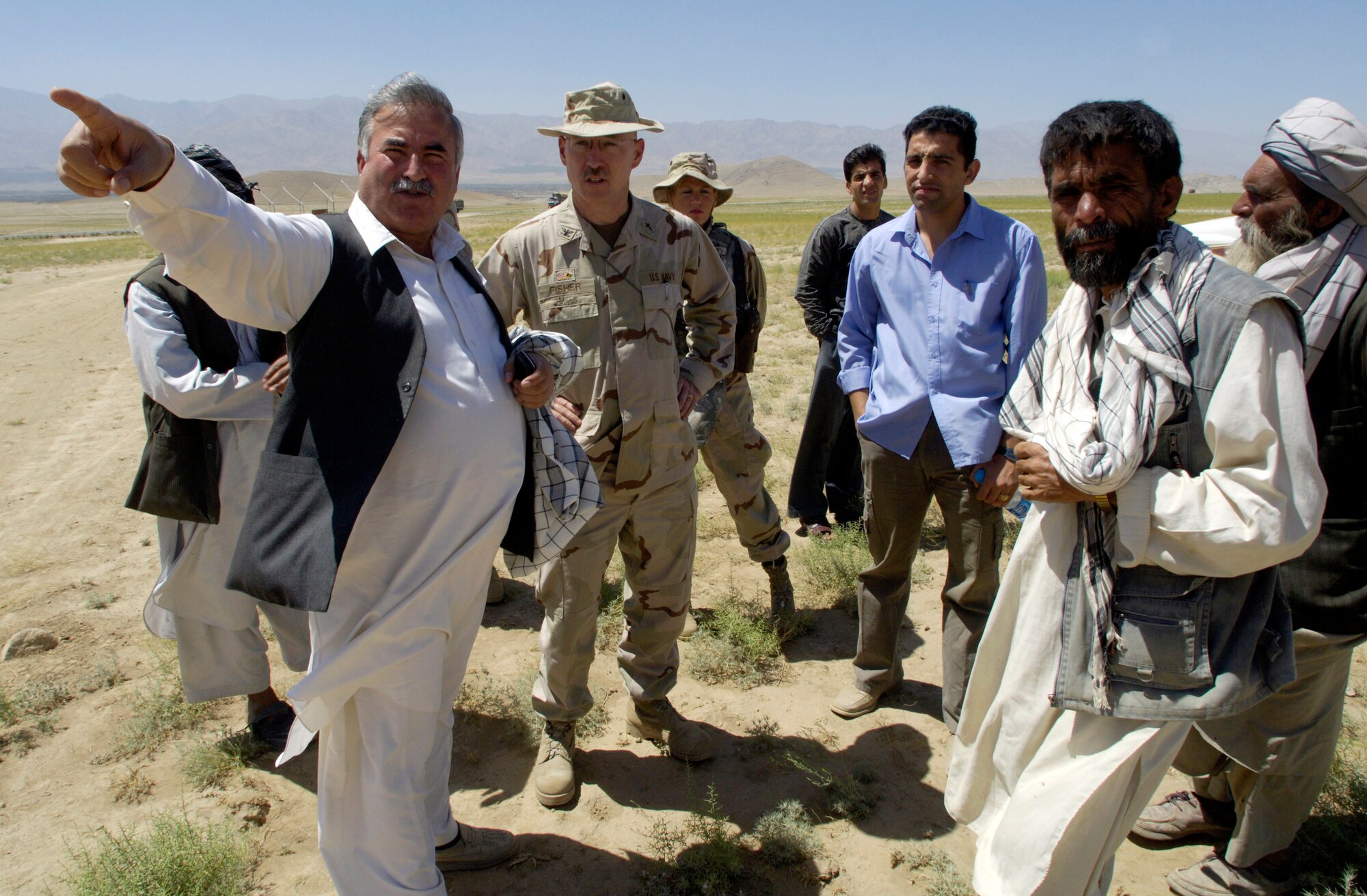 Navy Chaplain (Capt.) James Fisher (second from left) listens as Mohammad Khan (left), explains the most pressing needs July 27 at an Internal Displaced Persons camp outside of Kabul, Afghanistan. Chaplain Fisher is the Combined Security Transition Command-Afghanistan command chaplain, and Mr. Khan is the assistant director of Sozo International, a relief agency based in Louisville, Ky. (U.S. Air Force photo/Master Sgt. Jim Varhegyi)
