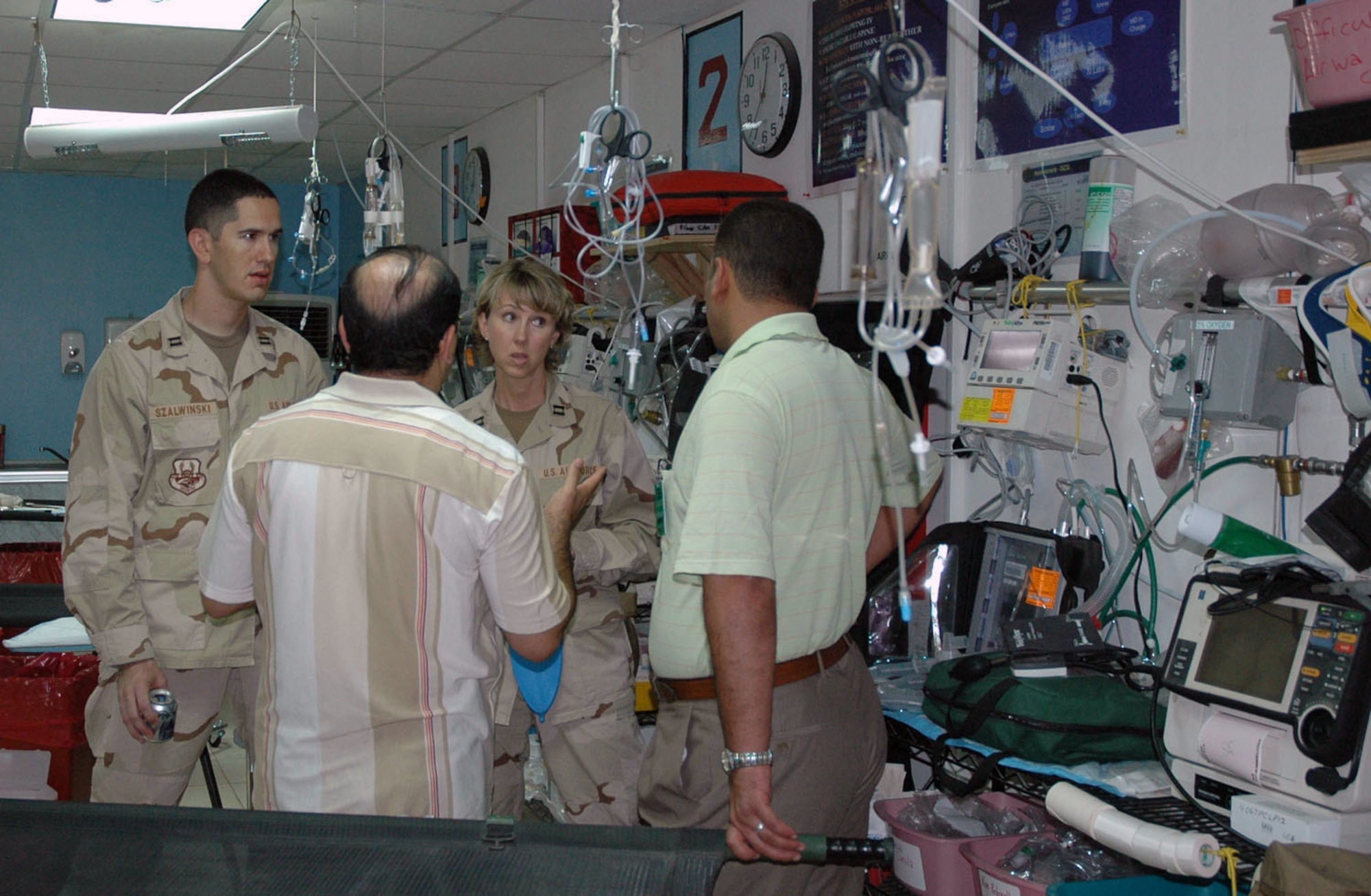 Capts. Bryan Szalwinski and Donna Strait chat with two local Iraqi physicians July 22 during a tour of the emergency room at the Kirkuk Air Base, Iraq, hospital.  The tour was part of a medical symposium that brought eight Iraqi physicians from downtown to the base to meet with about 20 U.S. Air Force and Army medical providers.  The captains are assigned to the 506th Expeditionary Medical Squadron.  (U.S. Air Force photo)