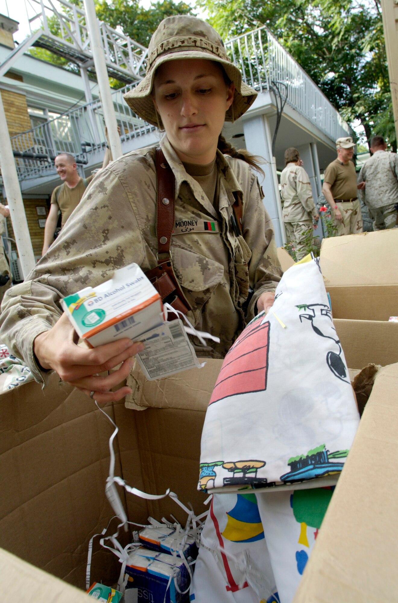 Canadian Navy Lt. Haley Mooney joins other volunteers from the Combined Security Transition Command-Afghanistan July 23 to sort donations sent from the United States to Camp Eggers in Kabul, Afghanistan. The volunteers, made up of joint and international military members, civil servants and contractors from throughout the CSTC-A, gather every two weeks to sort and package the clothing, toys, school supplies and toiletries which will be distributed in the Kabul area. (U.S. Air Force photo/Master Sgt. Jim Varhegyi)