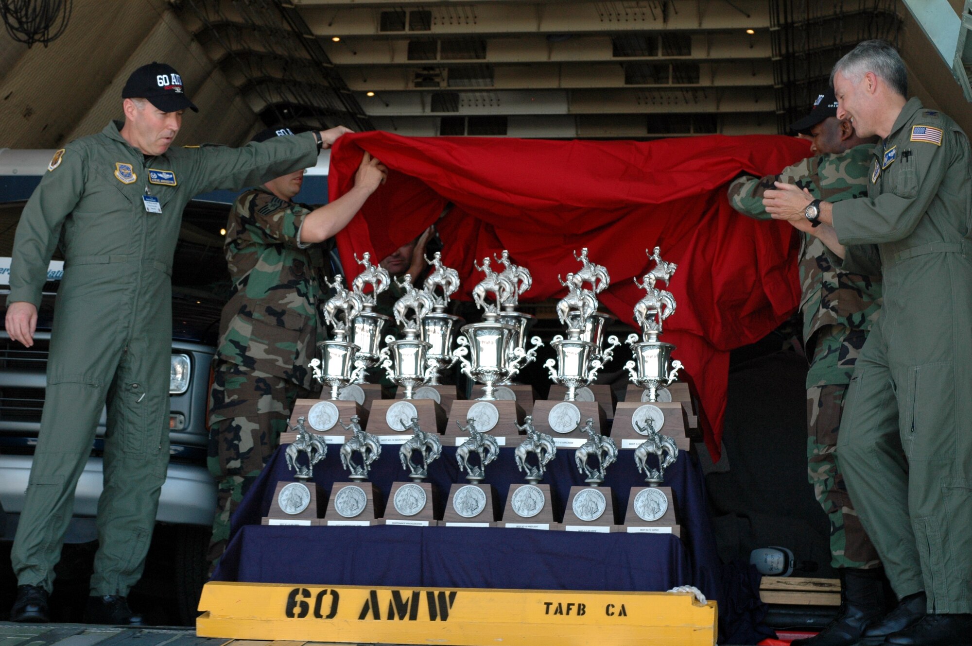 Col. Steve Arquiette, (left), 60th Air Mobility Wing commander, lifts the veil and shows the trophies won by Team Travis during the 2007 Air Mobility Command’s Expeditionary Rodeo. Team Travis earned 17 awards, including “Best Air Mobility Team” during the competition held at McChord Air Force Base, Wash., July 21-27. (U.S. Air Force photo/Staff Sgt. Matthew McGovern)