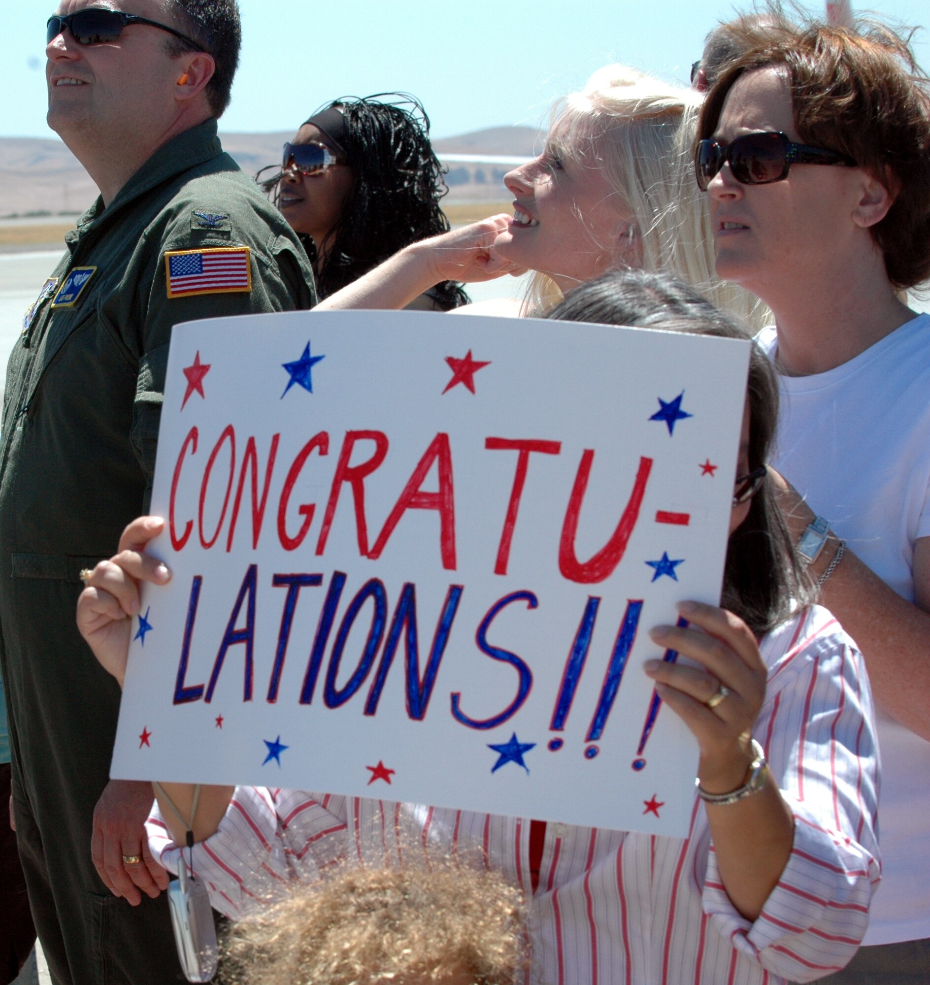 A family member holds up a sign congratulating Team Travis during the “Welcome Home” ceremony July 28. Team Travis earned 17 awards, including “Best Air Mobility Team” during the 2007 Air Mobility Command’s Expeditionary Rodeo, held at McChord Air Force Base, Wash., July 21-27. Rodeo 2007, hosted by Air Mobility Command, is a readiness competition between U.S. and international mobility air forces. It focuses on improving warfighting capabilities and support of the Global War on Terror. (U.S. Air Force photo/Staff Sgt. Matthew McGovern)